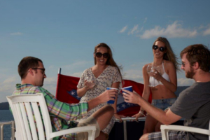 Two boys and two girls on deck talking and drinking